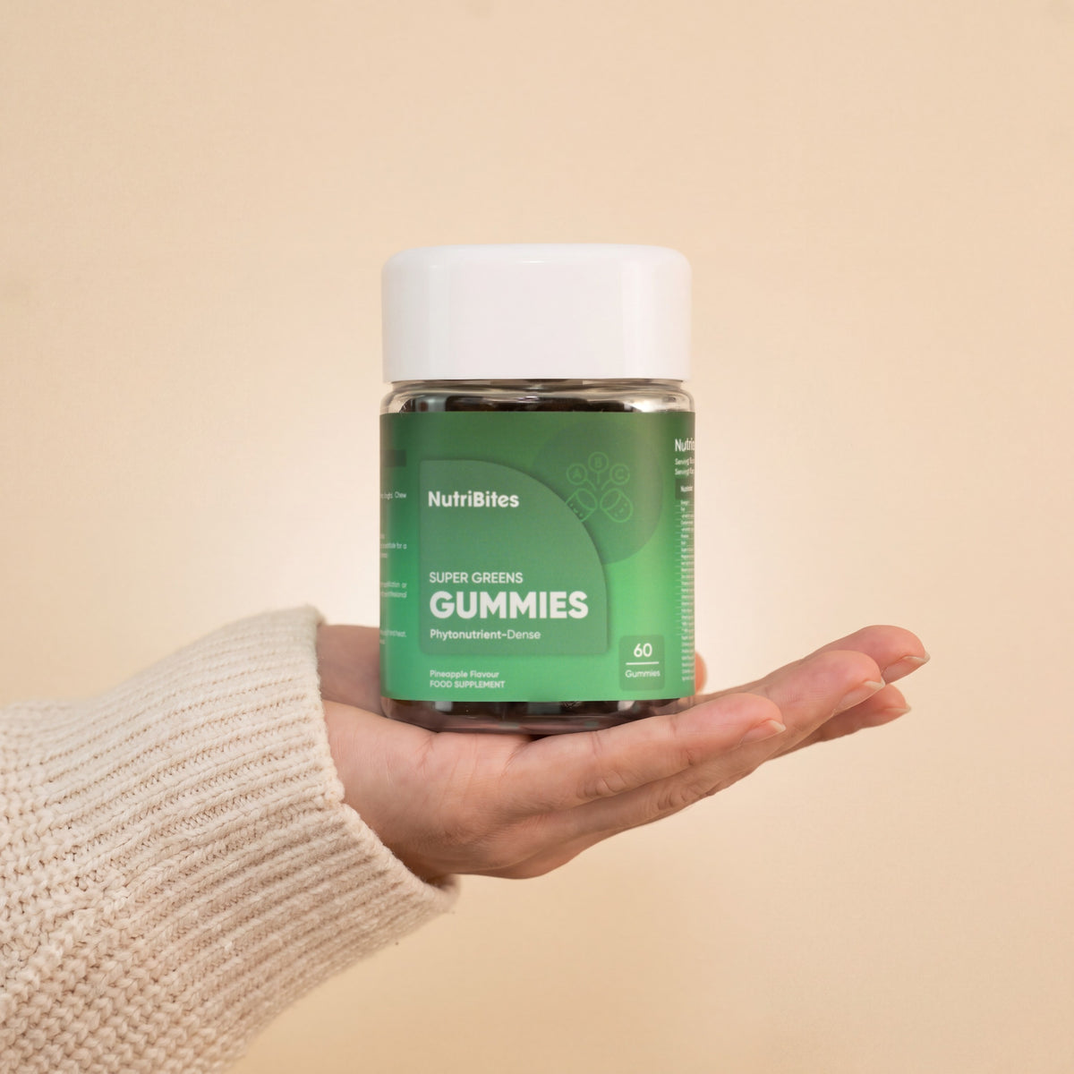 NutriBites Super Greens Gummies, pineapple flavour: jar held in a hand